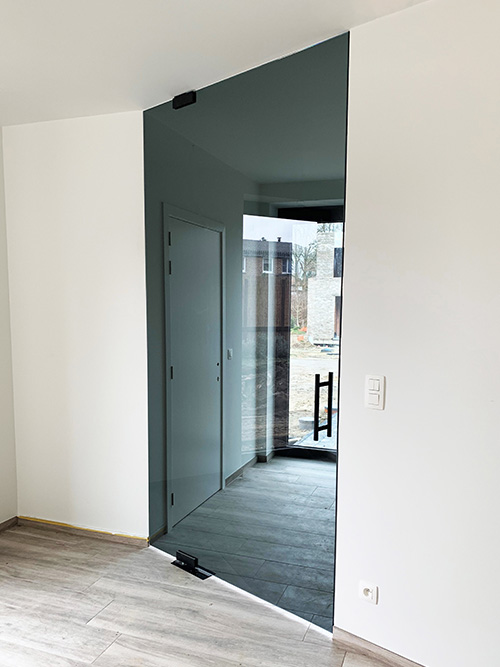 Glazen taatsdeur met grijs getint glas en mat zwarte scharnieren met mat zwarte deurgreep